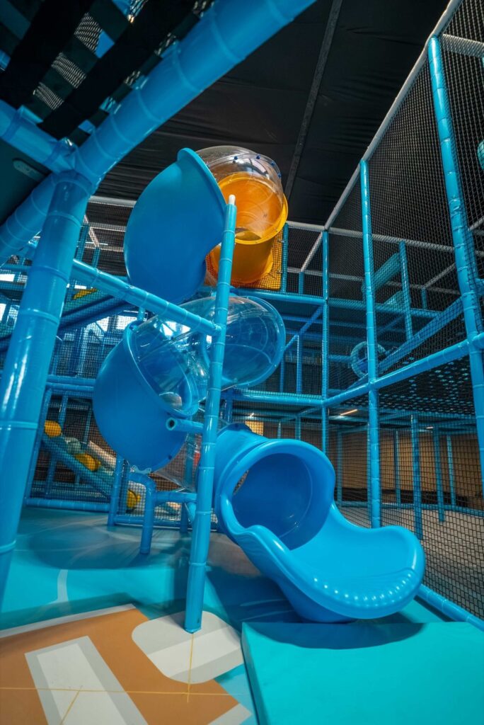 Spielturm im DELPHINN mit blauen Röhrenrutschen und Kletterebenen