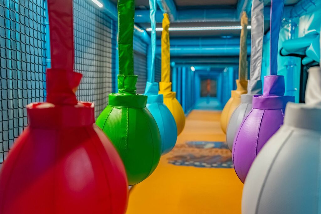 Parcours mit hängenden bunten Boxsäcken im Spielturm